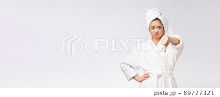 Beauty portrait asian woman looking on camera showing thumb down isolated over white background copy space. Beauty portrait asian woman looking on camera showing thumb down isolated over white background copy space. 89727321