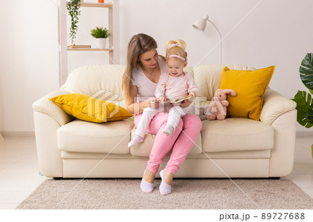 Child girl with cochlear implant with her mother at home. Hear impairment and deaf community concept Child girl with cochlear implant with her mother at home. Hear impairment and deaf community concept 89727688