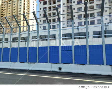 SELANGOR, MALAYSIA - JULY 18, 2020: Noise barriers are installed along the vehicle lane bordering the residence to prevent noise pollution to the surrounding locals. 89728163