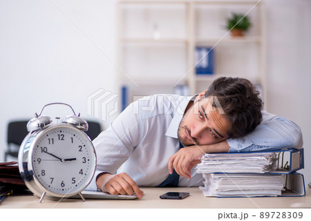 Young male employee in oversleeping concept Young male employee in oversleeping concept 89728309