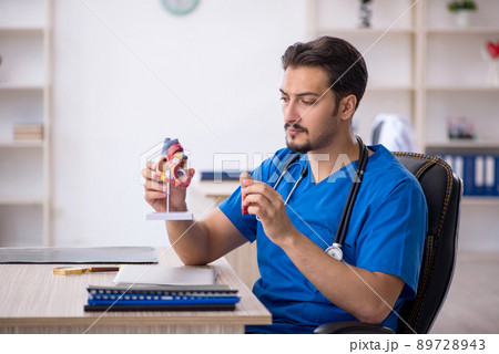 Young male doctor cardiologist working in the clinic Young male doctor cardiologist working in the clinic 89728943