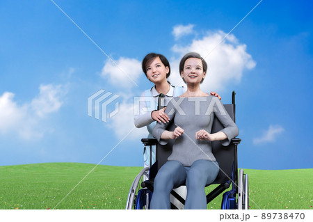 青い空と緑の芝生を背景に、笑顔のおばあちゃんの肩に手を置く介護士の女性 89738470