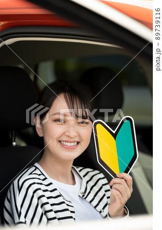 運転席で初心者マークを持つ笑顔の若い女性 運転席で初心者マークを持つ笑顔の若い女性 89739116