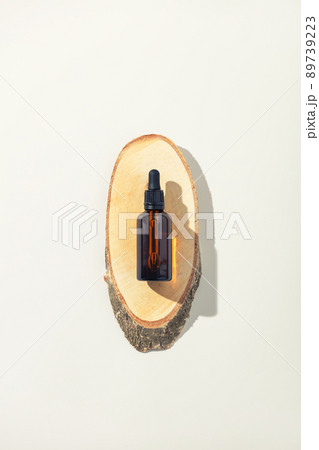 Amber glass bottle on wooden podium, white background. Natural cosmetic products packaging design template, branding Amber glass bottle on wooden podium, white background. Natural cosmetic products packaging design template, branding 89739223