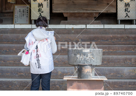 四国霊山寺でお遍路用の服でお参りをしている女性 89740700