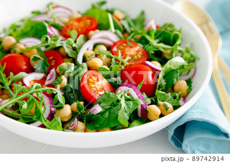 Vegetarian chickpea salad with tomatoes, arugula, parsley, spinach and red onion. Healthy food, diet Vegetarian chickpea salad with tomatoes, arugula, parsley, spinach and red onion. Healthy food, diet 89742914