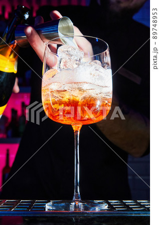 Bartender prepares Aperol Spritz cocktail on bar counter. Close-up, selective focus 89748953