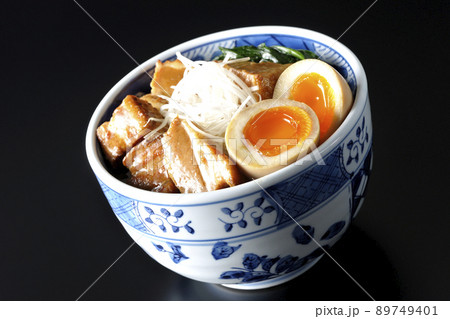トロトロ半熟卵とほうれん草と白髪葱が乗った豚の角煮丼を黒背景で撮影 89749401