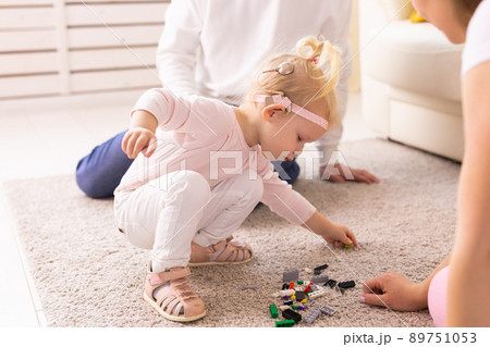 Cochlear implant on the child girl head and playing with mother and father. Hearing aid and deafness and innovative health technology concept Cochlear implant on the child girl head and playing with mother and father. Hearing aid and deafness and innovative health technology concept 89751053