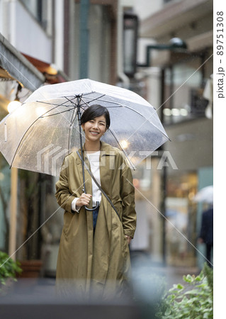 ビニール傘をさしたカメラ目線で笑顔の若い女性 ビニール傘をさしたカメラ目線で笑顔の若い女性 89751308