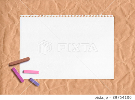 クラフト紙とスケッチブック、暖色パステルの背景 89754100