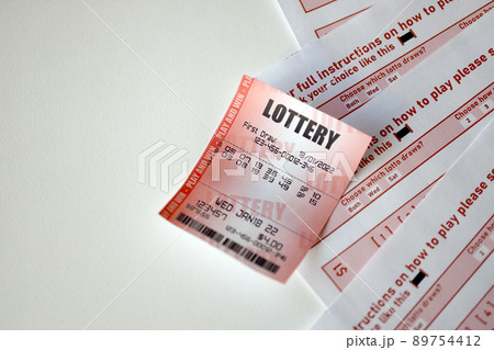 Red lottery ticket lies on pink gambling sheets with numbers for marking to play lottery. Lottery playing concept or gambling addiction. Close up 89754412