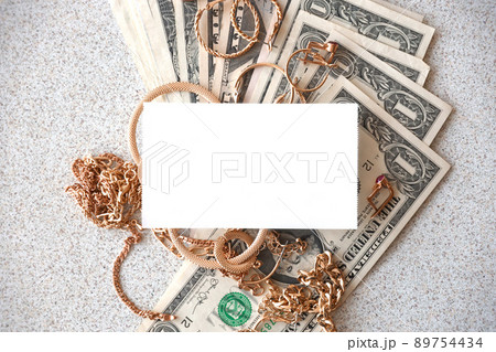 Many expensive golden jewerly rings, earrings and necklaces with big amount of US dollar bills with copy space. Pawnshop or jewerly shop Many expensive golden jewerly rings, earrings and necklaces with big amount of US dollar bills with copy space. Pawnshop or jewerly shop 89754434