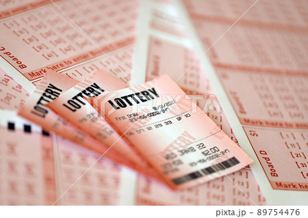 Red lottery ticket lies on pink gambling sheets with numbers for marking to play lottery. Lottery playing concept or gambling addiction. Close up 89754476