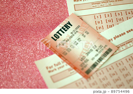 Red lottery ticket lies on pink gambling sheets with numbers for marking to play lottery. Lottery playing concept or gambling addiction. Close up Red lottery ticket lies on pink gambling sheets with numbers for marking to play lottery. Lottery playing concept or gambling addiction. Close up 89754496
