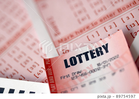 Red lottery ticket lies on pink gambling sheets with numbers for marking to play lottery. Lottery playing concept or gambling addiction. Close up Red lottery ticket lies on pink gambling sheets with numbers for marking to play lottery. Lottery playing concept or gambling addiction. Close up 89754597