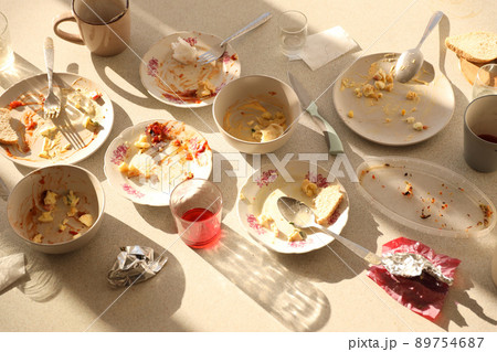 Empty dirty plates with spoons and forks on the table after meal. Banquet ending concept. Unwashed dishes 89754687