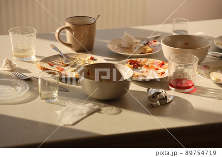 Empty dirty plates with spoons and forks on the table after meal. Banquet ending concept. Unwashed dishes 89754719