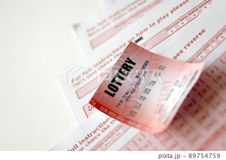 Red lottery ticket lies on pink gambling sheets with numbers for marking to play lottery. Lottery playing concept or gambling addiction. Close up 89754759