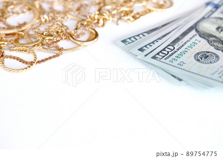 Many expensive golden jewerly rings, earrings and necklaces with big amount of US dollar bills on white background. Pawnshop or jewerly shop Many expensive golden jewerly rings, earrings and necklaces with big amount of US dollar bills on white background. Pawnshop or jewerly shop 89754775