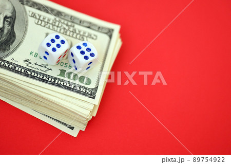 Money, finance and gambling concept. Close up on an American hundred US dollar banknotes and two white dice on top showing the numbers six Money, finance and gambling concept. Close up on an American hundred US dollar banknotes and two white dice on top showing the numbers six 89754922
