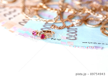 Many expensive golden jewerly rings, earrings and necklaces with big amount of Ukrainian money bills. Pawnshop or jewerly shop concept. Jewelry trading Many expensive golden jewerly rings, earrings and necklaces with big amount of Ukrainian money bills. Pawnshop or jewerly shop concept. Jewelry trading 89754943