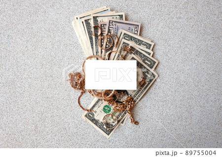 Many expensive golden jewerly rings, earrings and necklaces with big amount of US dollar bills with copy space. Pawnshop or jewerly shop 89755004