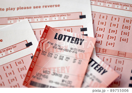 Red lottery ticket lies on pink gambling sheets with numbers for marking to play lottery. Lottery playing concept or gambling addiction. Close up 89755006