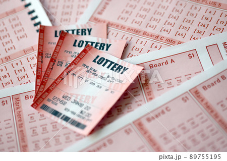 Red lottery ticket lies on pink gambling sheets with numbers for marking to play lottery. Lottery playing concept or gambling addiction. Close up 89755195