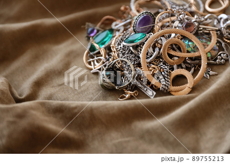 Bunch of stolen jewelry on military uniform cloth fabric. Looting by Russian soldiers in the Ukrainian cities during the Russian attack on Ukraine. Marauders and looters Bunch of stolen jewelry on military uniform cloth fabric. Looting by Russian soldiers in the Ukrainian cities during the Russian attack on Ukraine. Marauders and looters 89755213
