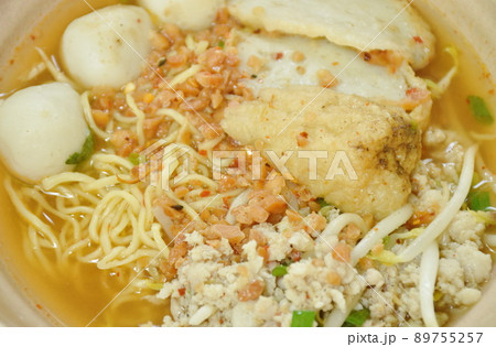 Chinese egg yellow noodles topping chop pork and fish ball in spicy tom yum soup on bowl 89755257