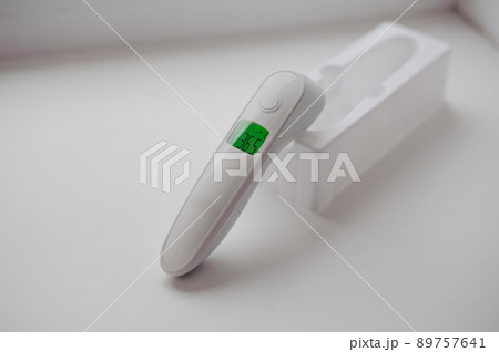 Non-contact thermometer on a white background for measuring body temperature 89757641