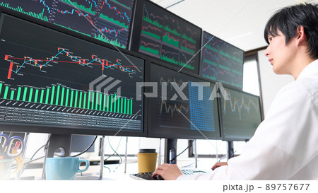 マルチモニターのチャートを見つめる若いビジネスパーソン　トレーダー　投資家　イメージ 89757677
