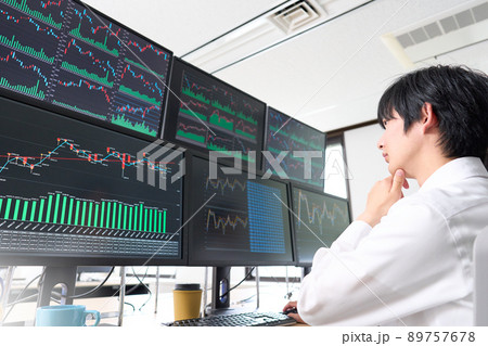 マルチモニターのチャートを見つめる若いビジネスパーソン　トレーダー　投資家　イメージ 89757678