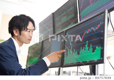 マルチモニターの画面を指差すビジネスパーソン　トレーダー　イメージ 89757699