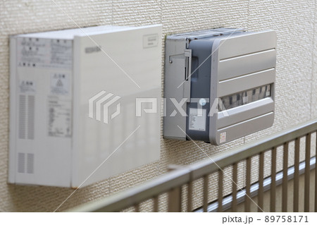 住宅の壁に設置された家庭用蓄電池設備とパワコン 89758171