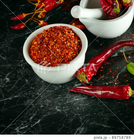 Chili pepper and pepper powder on a black . 89758789