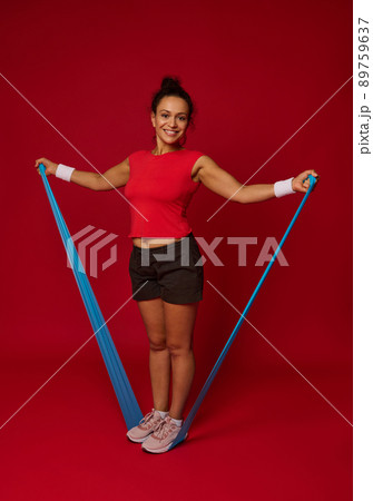 Full length of a sporty woman using elastic fitness rubber band