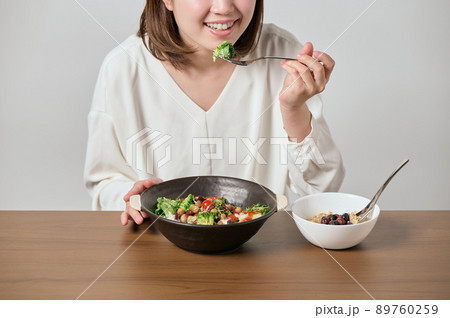 サラダとオートミールを食べる若いヴィーガン女性 89760259