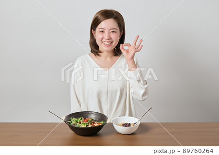 サラダとオートミールを食べる前にOKのポーズをする若い女性 サラダとオートミールを食べる前にOKのポーズをする若い女性 89760264