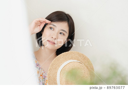 日射しを避ける女性 89763077