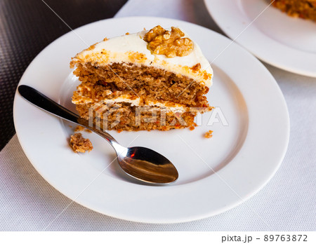 Slice of soft carrot cake with cream cheese glaze on wooden table Slice of soft carrot cake with cream cheese glaze on wooden table 89763872