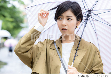 梅雨　髪の広がりを気にする女性 89765849