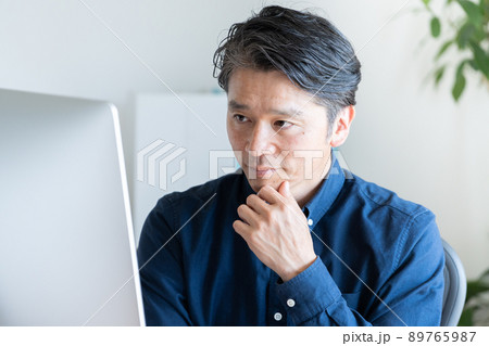 デスクトップパソコンを使うビジネスマン（ビジネス・カジュアル・ミドル男性） 89765987