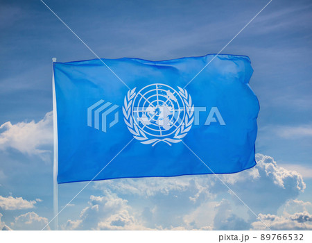 Flag of the United Nations. United Nations flag on sky background. UN symbol. 89766532