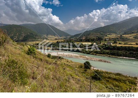 The Punakha Suspension Bridge at the Punakha Dzong. Across the Tsang Chu River to Shengana and Wangkha village. The longest suspension bridge in Bhutan and always decorated with colorful prayer flags. 89767264