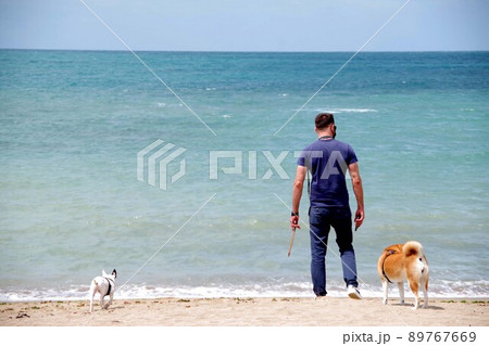 台湾淡水の海にて男と二匹の犬 台湾淡水の海にて男と二匹の犬 89767669