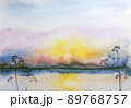 Blue watercolor illustration of multicolored sunset on sea with forest on horizon. 89768757