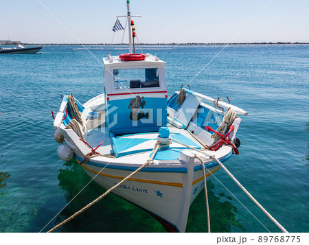 Tinos, Greece - July 02, 2021: Traditional Fisher boat in the harbor of Tinos, a Greek island situated in the Aegean Sea. It is located in the Cyclades archipelago. Anciently, the island called Tenos. 89768775
