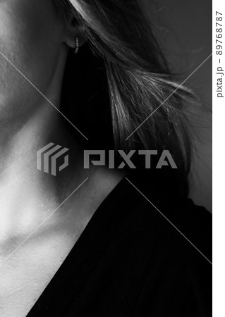 Young tender well-groomed woman's neck in a photo in black and white. Vertical photo. Young tender well-groomed woman's neck in a photo in black and white. Vertical photo. 89768787